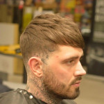 man with tattoos getting hair cut